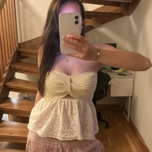 Zara topp - Säljer en superfin beige axelbandslös topp med spetsdetaljer. Den har en stickad överdel och en luftig, broderad nederdel med blommönster. Perfekt för sommardagar eller en avslappnad festkväll. Passar bra till både jeans och kjol!