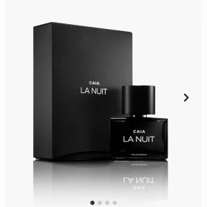 Svart parfymflaska från CAIA - Säljer en elegant och mystisk parfym från CAIA, La Nuit. Flaskan är helsvart med en minimalistisk design och har en stilren vit text. Perfekt för kvällar när du vill känna dig extra speciell. 