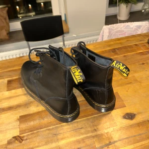 Svarta Dr. Martens boots - Säljer ett par klassiska svarta Dr. Martens boots i skinn. De har AirWair-fliken bak och är i riktigt bra skick då jag aldrig har använt de.