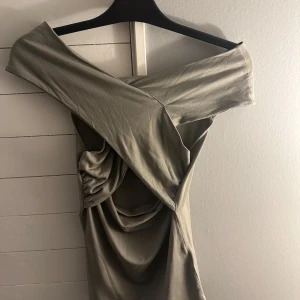 Omlottopp - Snygg grön topp från Gina Tricot med offshoulder-design och omlott draperad detalj. Perfekt för en stilren look och till vardags.