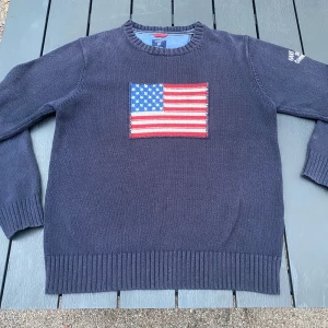 Mörkblå bomullströja från GANT - Säljer en limited edition GANT x USA i 100% bomull. Tröjan har en broderad amerikansk flagga på framsidan och text på ärmen. Perfekt för vintern och väldigt bekväm. Storleken är m, men skulle säga att den passar en person med S och M.