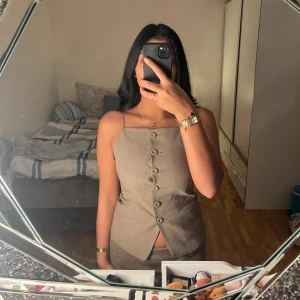 Beige väst med knappar. Ej använd - Snygg beige väst med knappar framtill. Perfekt för en stilren look. Västen har en klassisk design med smal passform.