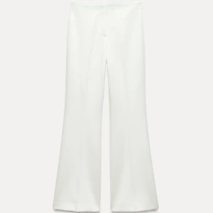 Vita kostymbyxor -  vita kostymbyxor med hög midja och en stilren design. Byxorna har en rak passform och är perfekta och är endast använda en gång. Bootcut och väldigt mjukt material
