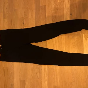 Svarta byxor i storlek S - Snygga svarta byxor i storlek S. Perfekta för en stilren look med en tight passform. De är tillverkade i ett bekvämt material som passar till många olika tillfällen.