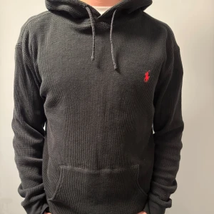 Polo Ralph lauren stickad hoodie - Säljer en svart stickad hoodie från Polo Ralph Lauren. Hoodien är i bra skick och är i storlek L. Jag säljer hoodien då den passar inte🫤                                             Ny pris ligger på ca: 2000 kr.                                         Hoodien är väldigt skön och passar bra nu till vintern. Om ni behöver mer info så är det bara att höra av sig i dm🙌