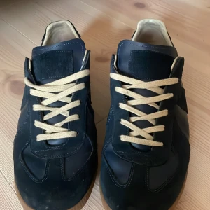 Navy blåa maison margiela GATs - Säljer detta läckra paret för ett pris du inte kan hitta någon annan stans. Skick 7/10. Är en utmärkt julklapp och man kan ha de till vilken outfit som helst! Köpta nya på ebay! Priset är inte skrivet i sten men iaf ett rimligt förslag. Om du har några frågor eller vill ha fler bilder tveka inte på att höra av dig!