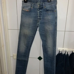 Blå jeans från Diesel - Snygga blå jeans från Diesel med en slim-carrot passform. Modellen heter Tepphar och har en klassisk femficksdesign med en liten logga på myntfickan. Jeansen har en lätt tvättad look och är tillverkade i stretchmaterial för extra komfort.