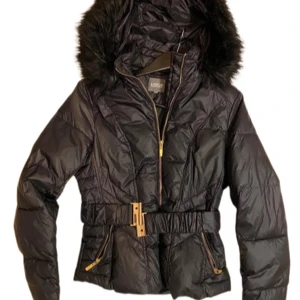 Svart dunjacka med pälsdetaljer - Snygg svart dunjacka från Luxe med huva och pälsdetaljer. Luvan går att ta av. Perfekt för kyliga dagar. Den är enbart testad och jag säljer den då den är för liten. Pris kan självklart diskuteras 