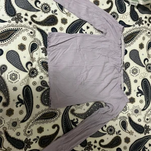 Ljuslila ribbad topp från FB Sister - Säljer en ljuslila ribbad topp från FB Sister. Toppen har långa ärmar och en offshoulder-design som ger en trendig look. Perfekt för att styla med jeans eller kjol.