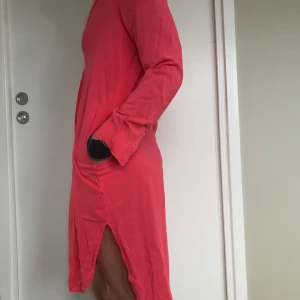 Korall klänning/kaftan Stl S Nyskick  - Korallfärgad klänning/kaftan med ficka på vänster sida och är något längre baktill än framtill. Färgen inte lika intensiv i verkligen. Zara Stl S. 100% viscose helt underbar kvalitet, såå mjuk o skön. Använd en gång, nytvättad är i nyskick.  Säljer även matchande sandaler H&M Stl 38, se mina övriga annonser.