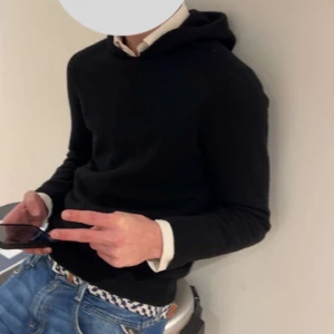 Svart ull hoodie - Svart Ull Hoodie som formar sig schysst efter kroppen säljer då den blivit för liten den sitter ungefär om XS kom privat för fler bilder. Mvh 