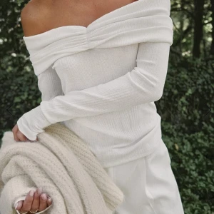 Vit offshoulder topp - Elegant vit offshoulder topp med långa ärmar och ribbad struktur. Ordinarie pris: 400kr (ex frakt kostnad) , aldrig använt. SIZE: 34-36 