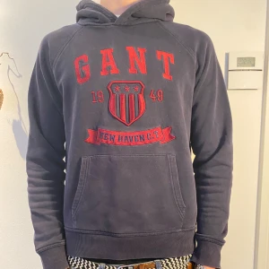 Mörkblå GANT hoodie - GANT | Snygg mörkblå hoodie med röd text och emblem på framsidan | skick 8/10  | Pris går att diskutera vid snabb affär!