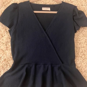 Mörkblå omlottblus från Holly & White - Snygg blus från Holly & white, använd fåtal gånger väldigt fint skick. Säljer då de ej är min stil.