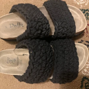 Svarta sandaler från Duffy - Snygga svarta sandaler från Duffy med flätade remmar. Perfekta för en avslappnad sommarlook. Sandalerna har en bekväm sula och är lätta att bära.