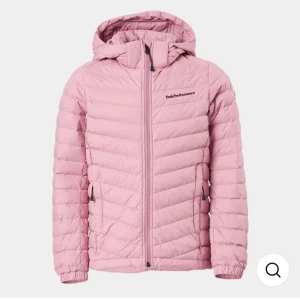 Rosa dunjacka från Peak Performance - Snygg rosa dunjacka från Peak Performance med huva och dragkedja framtill. Jackan har en quiltad design och långa ärmar, perfekt för kyligare dagar. Den är både stilren och funktionell, idealisk för höst och vinter.nypris 2800kr nästan aldrig använd 