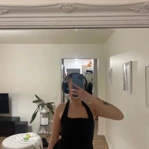 Svart ärmlös topp med snörning - Snygg svart ärmlös topp med snörning i ryggen. Perfekt för en trendig look. Toppen har en tight passform och är idealisk för sommarens varma dagar.