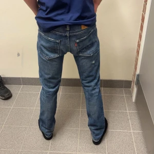 Levi's 501 - Säljer ett par klassiska Levi's 501 CT jeans i blå denim. De har en vintage look med lite slitage för en cool stil. Perfekta för både vardag och fest! Passformen är straight och de har en knappgylf.