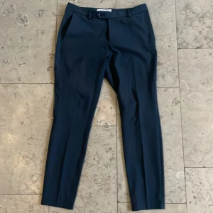 Kostymbyxor från SNT - Nypris :  1499kr !!!!    Sjukt snygga och framförallt också bekväma kostymbyxor i slimfit från Shaping new tomorrow. Ni har säkert fått upp reklam kring detta danska klädmärke och att de är sjukt sköna och stretchiga är 100% sanningen. Byxorna är i navy melange (blå) och passar utmärkt med kavaj i liknande färg men även vanliga tröjor/ vit skjorta. Endast goda omdömen här på plick så ni kan vara säkra på att ni får en god affär!