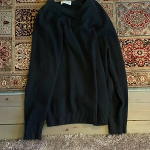 Marin blåtröja från Selected Homme - Säljer en stilren marin blå tröja från Selected Homme. Tröjan har en rund halsringning och långa ärmar med ribbade muddar. Perfekt för en klassisk look.