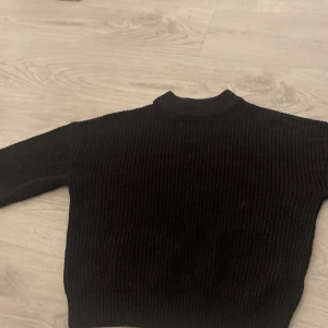 Svart stickad tröja från FB Sister - Säljer en svart stickad tröja från FB Sister i storlek XS. Tröjan har en ribbad design och långa ärmar, perfekt för kyligare dagar. Enkel och stilren, passar till det mesta i garderoben.
