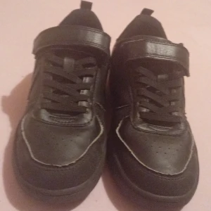 Svarta sneakers med kardborreband - Snygga svarta sneakers med både snörning och kardborreband för extra komfort och stil. Perfekta för en avslappnad look.