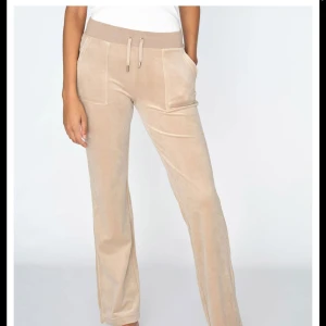 Beige velourbyxor från Juicy Couture - Snygga beige velourbyxor från Juicy Couture, bra skick liten fläck på byxan men går o ta bort, nyskick. Säljer för 600 köpts för 1200