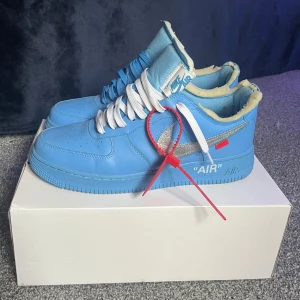 Off-White x Nike Air Force 1 Low MCA University Blue - ⚠️REPS⚠️ Ett par riktigt feta off-white af1 university blue. Väldigt bra kvalitet och knappast använda. Skum-kanten är ganska sliten men annars inga defekter. Box, tag och off-white snören, ett vitt o ett blått, kommer med.