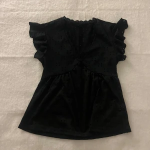 Broderad volangblus - Svart volangblus med hålbroderier som är i bra skick.