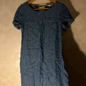 Blå jeansklänning från Esprit - Snygg blå jeansklänning från Esprit i storlek XS. Klänningen har korta ärmar och en rund halsringning. Perfekt för en avslappnad stil med en touch av denim.