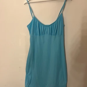 Blå ribbad klänning från Primark - Snygg blå ribbad klänning från Primark med smala axelband. Klänningen har en figursydd form och aldrig använd 