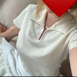 Cremevit topp med krage  - Säljer en stilren vit topp med korta ärmar och en klassisk krage. I strl S, helt oanvänd 