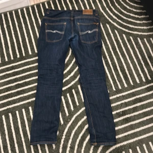 Mörkblå jeans från Nudie Jeans - Hej! Säljer ett par feta nudie jeans billigt! Jeansen är i bra skick och är i storlek W32 L32. Tveka inte på att höra av dig vid minsta lilla fundering. Priset är ej fast i sten! 👖😁