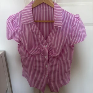 Söt rosa-randig skjorta  - En supersöt rosa-randig kortärmad skjorta. Perfekt för våren och sommaren😍aldrig använd, så helt i nyskick. Skriv för fler bilder💕