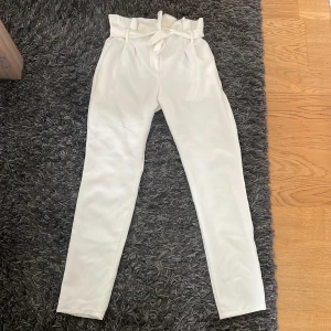 Kostymbyxor - Vita kostymbyxor med knytning och knappar från diabless.