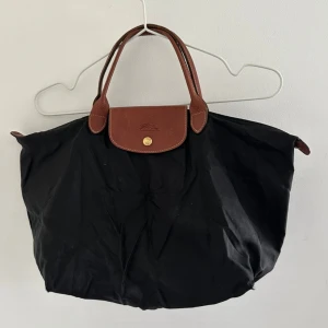 Longchamp väska - Superfin men har defekter på insidan och lite under. Säljes i befintligt skick Hör av dig vid frågor eller funderingar även om du vill ha fler bilder!