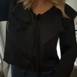 Blus med volang - Svart blus med volang från nakd, storlek 36💗