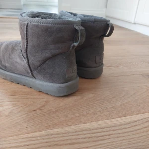 Gråa Uggs i storlek 39 - Ett par gråa Uggs i storlek 39. De är äkta och lite slitna där fram därav priset. Super mysiga att gå i och håller fötterna varma oavsett kyla. Var inte rädd att fråga om bilder ellelr liknande! Pris går att diskutera!