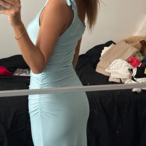 Blå klänning - Ljusblå längre klänning. En slits upp mot knäna. Super fin och aldrig använd. Rensar garderoben därför vill jag se intresset bara. Jag är xs och den formar kurvorna väldigt fin men tror även en s och mindre M kan passa eftersom den är stretchig