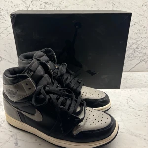 Nike Air Jordan 1 High Shadow - Säljer dessa Nike Air Jordan 1 Retro High Shadow. Skorna är i fint skick men använda. Storlek 44.5. Säljes på många ställen nya för cirka 8-12000. Missa inte detta kap! Original box ingår dock tyvärr inte. Inga returer. 