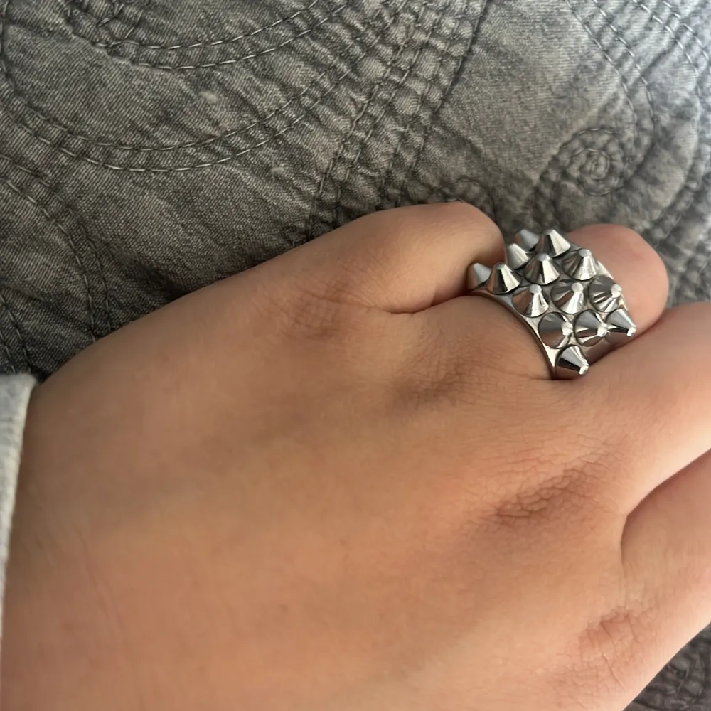 Säljer en snygg och modern silverfärgad ring från Edblad i storlek 16,80💗. Ringen har en unik design med små pyramidformade detaljer som ger den en cool och edgy look. Perfekt för att piffa upp vilken outfit som helst! . Accessoarer.