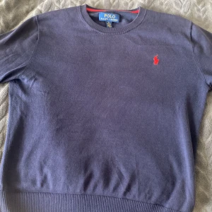 Polo Ralph Lauren Stickad Tröja 140-155 - 8,5/10 skick och har ett litet hål i vänstra armhålan men syns inte vid användning. Säljer pga rensar garderoben. Det är dåligt ljus på bilden tröjan är marinblå och mörkare i verkligheten. Nypris 1099kr mitt pris 199kr
