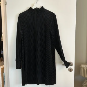 Svart långärmad klänning från Mywear - Säljer en elegant svart långärmad klänning från Mywear. Den har en ribbad struktur som ger en snygg och stilren look. Perfekt för höst- och vinterfester! 🖤