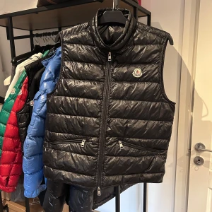 Moncler Gui väst - Moncler Gui väst i nyskick, bara blixtlåset som saknar en del men stänger som normalt med försiktighet. Storlek 2 passar s/m, nypris 9000 mitt pris 2700! Bara att skriva vid frågor eller funderingar, över 70 refs från nöjda kunder finns! 