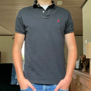 Ralph Lauren Piké  - Säljer nu denna svarta Ralph Lauren pikén den är i rätt så bra skick men den är lite tvättad i färgen. Dom två första bilderna är lånade och han på bilden är 180cm. Det är bara att höra av sig vid frågor om pikén eller om man vill ha flera bilder🥳🥳🥳