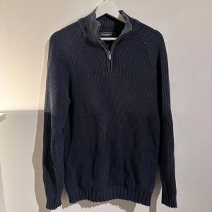 Mörkblå stickad tröja från Dressmann - Säljer en snygg och varm mörkblå stickad tröja från Dressmann. Den har en praktisk dragkedja vid halsen och långa ärmar. Perfekt för kyliga dagar och passar både till vardags och lite finare tillfällen.