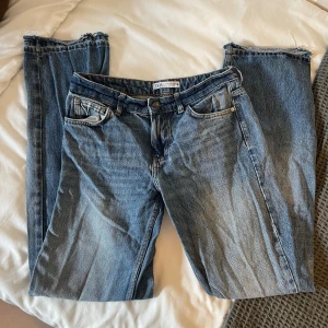 Blå jeans från Zara - Säljer ett par klassiska blå jeans från Zara. De har en straight fit och är tillverkade i denim med en snygg tvätt. Jeansen har fem fickor och stängs med dragkedja och knapp. Dom är midwaist