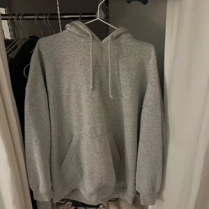 Basic grå hoodie - Säljer en klassisk grå hoodie med känguruficka och justerbar huva. Från weekday i storlek s men den är oversized!! 