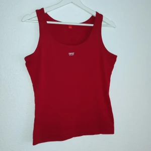 Röd linnetopp från Esprit - Snygg röd linnetopp från Esprit i ett mjukt och bekvämt material. Perfekt för varma dagar eller som ett lager under en jacka. Den har en enkel design med breda axelband och rund halsringning.