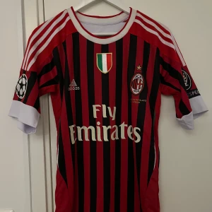 AC Milan fotbollströja med Prince 27 - Ac Milan hemma tröja från 2012/13 säsongen med CL märket på ärmarna samt Prince Boatengs namn på ryggen